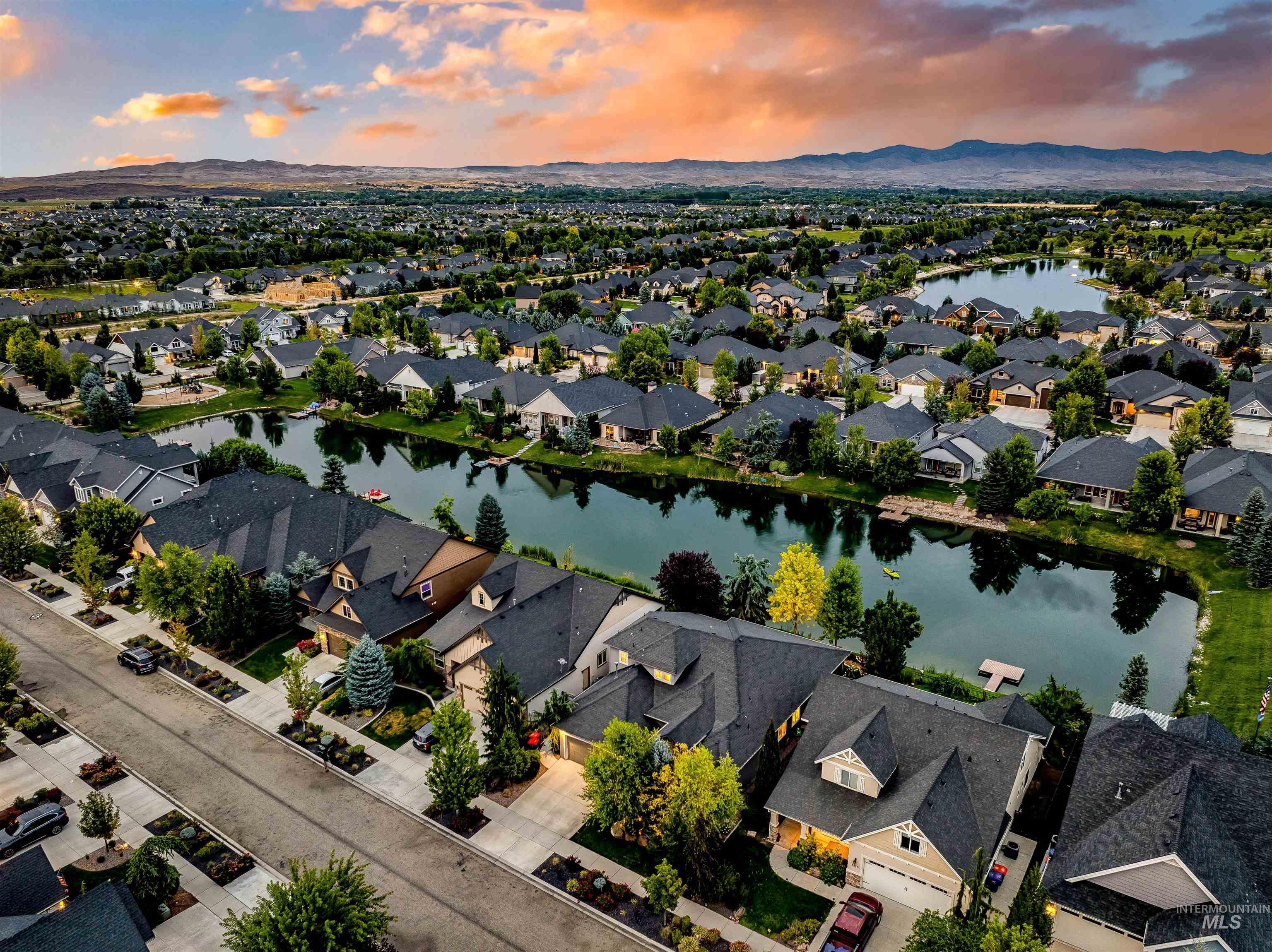 Aerial view of property and surrounding area with a water and mountain view and nearby suburban area