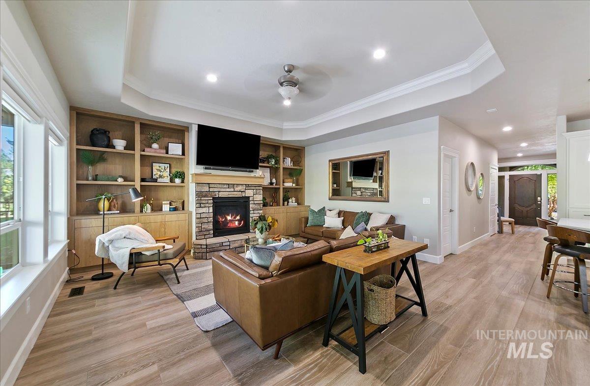 Living area with plenty of natural light, recessed lighting, ornamental molding, a ceiling fan, and light wood-type flooring