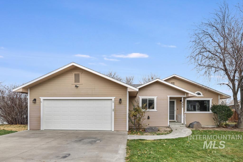 Single story home featuring concrete driveway, a garage, and a front lawn
