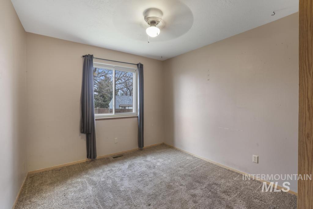 Carpeted bedroom featuring ceiling fan and baseboards