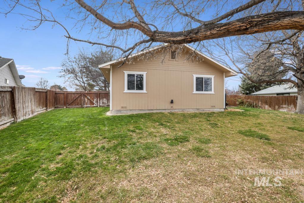 Back of house with a fenced backyard and a gate