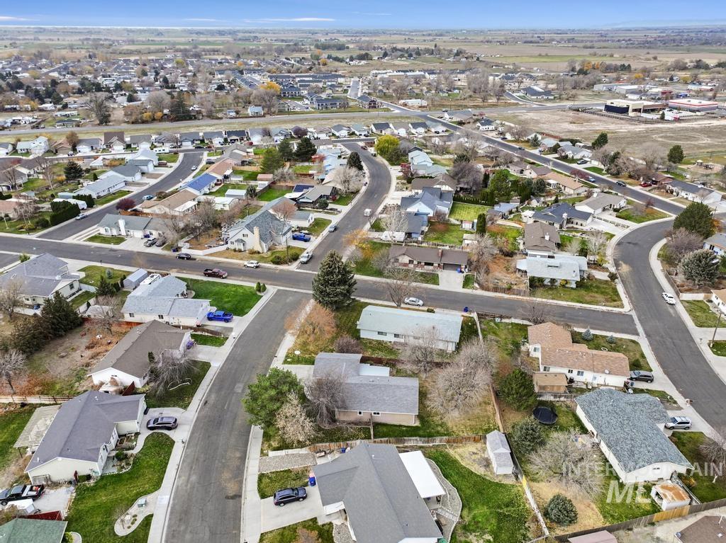 Aerial view of property and surrounding area with nearby suburban area