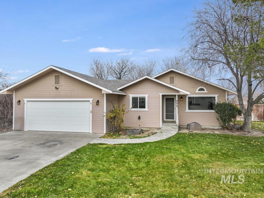 Ranch-style home with concrete driveway, a front lawn, and a garage