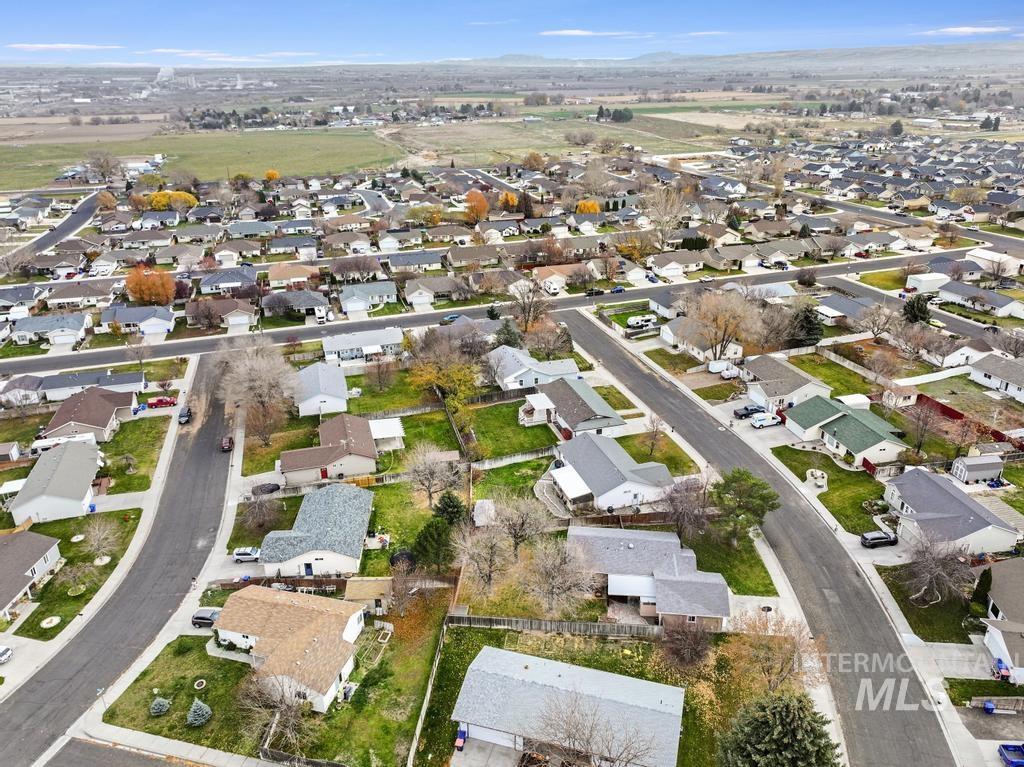 Aerial view of property and surrounding area featuring nearby suburban area