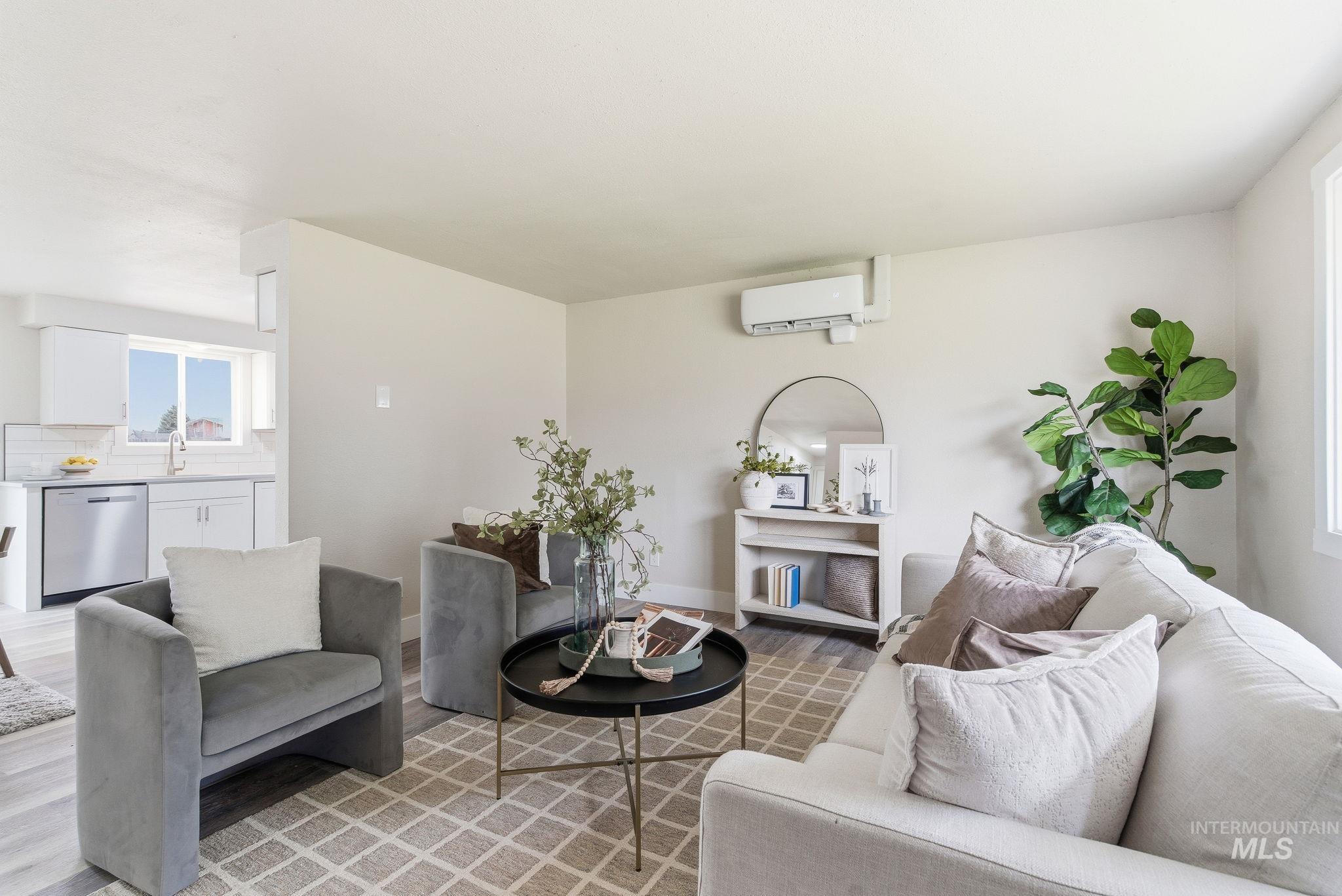 Living area with light wood finished floors and an AC wall unit