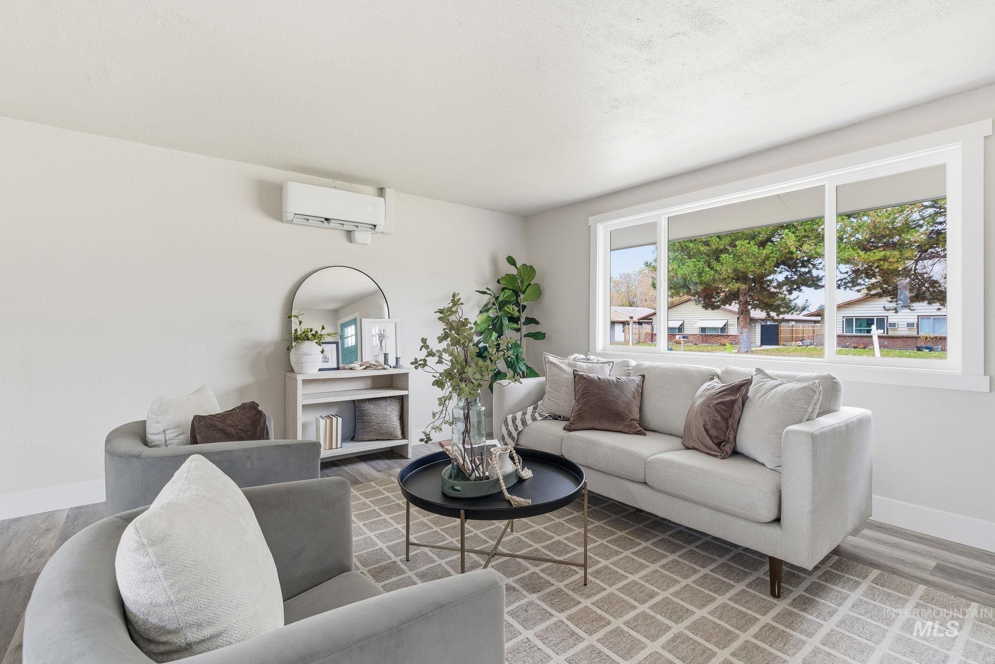 Living area with wood finished floors and an AC wall unit