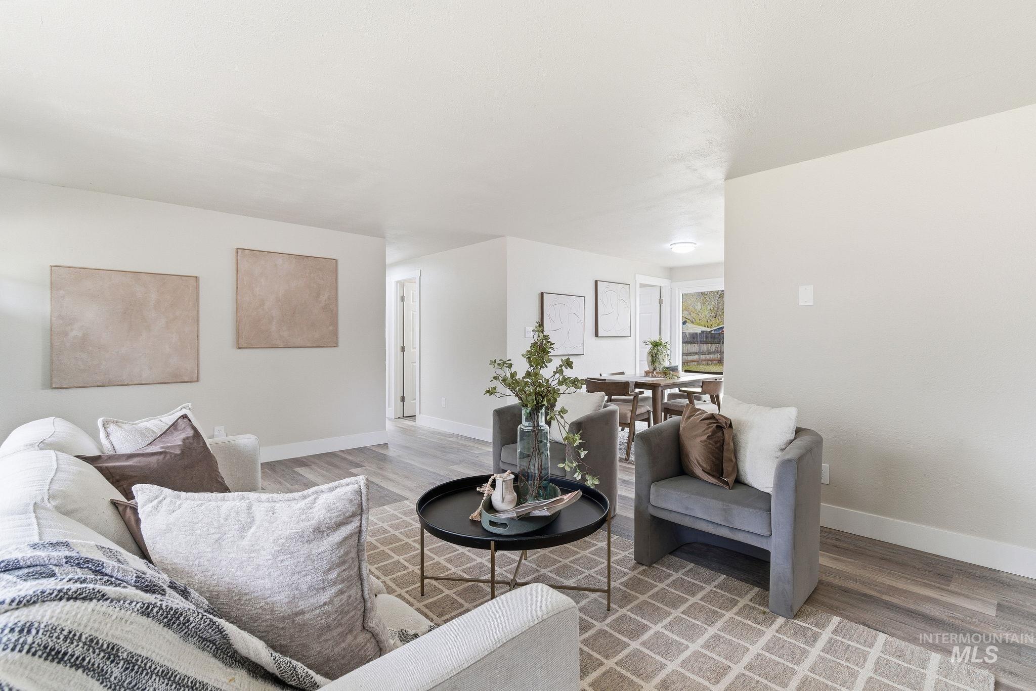 Living area featuring baseboards and light wood-type flooring