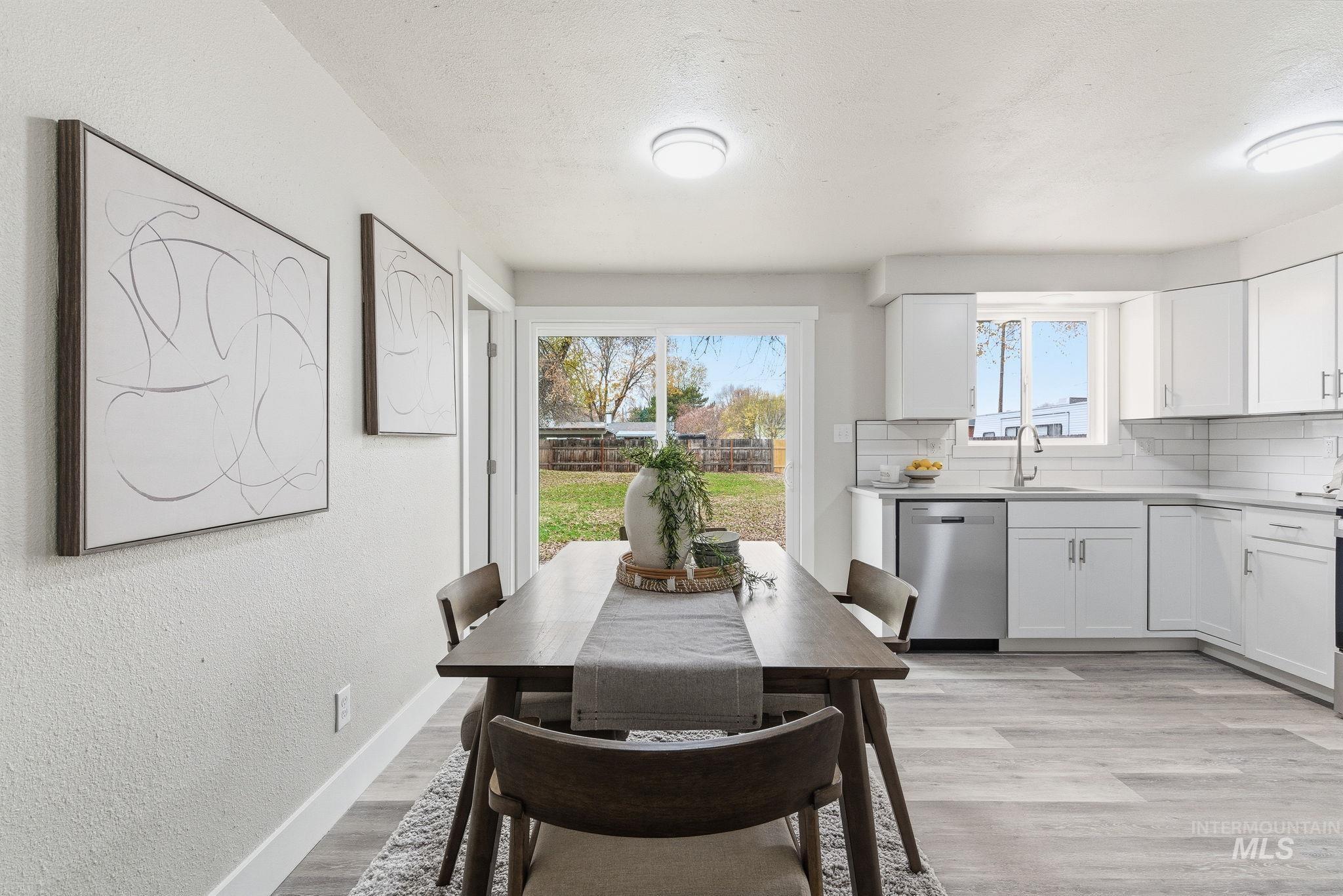 Dining space featuring light wood-style floors, a textured wall, and a textured ceiling