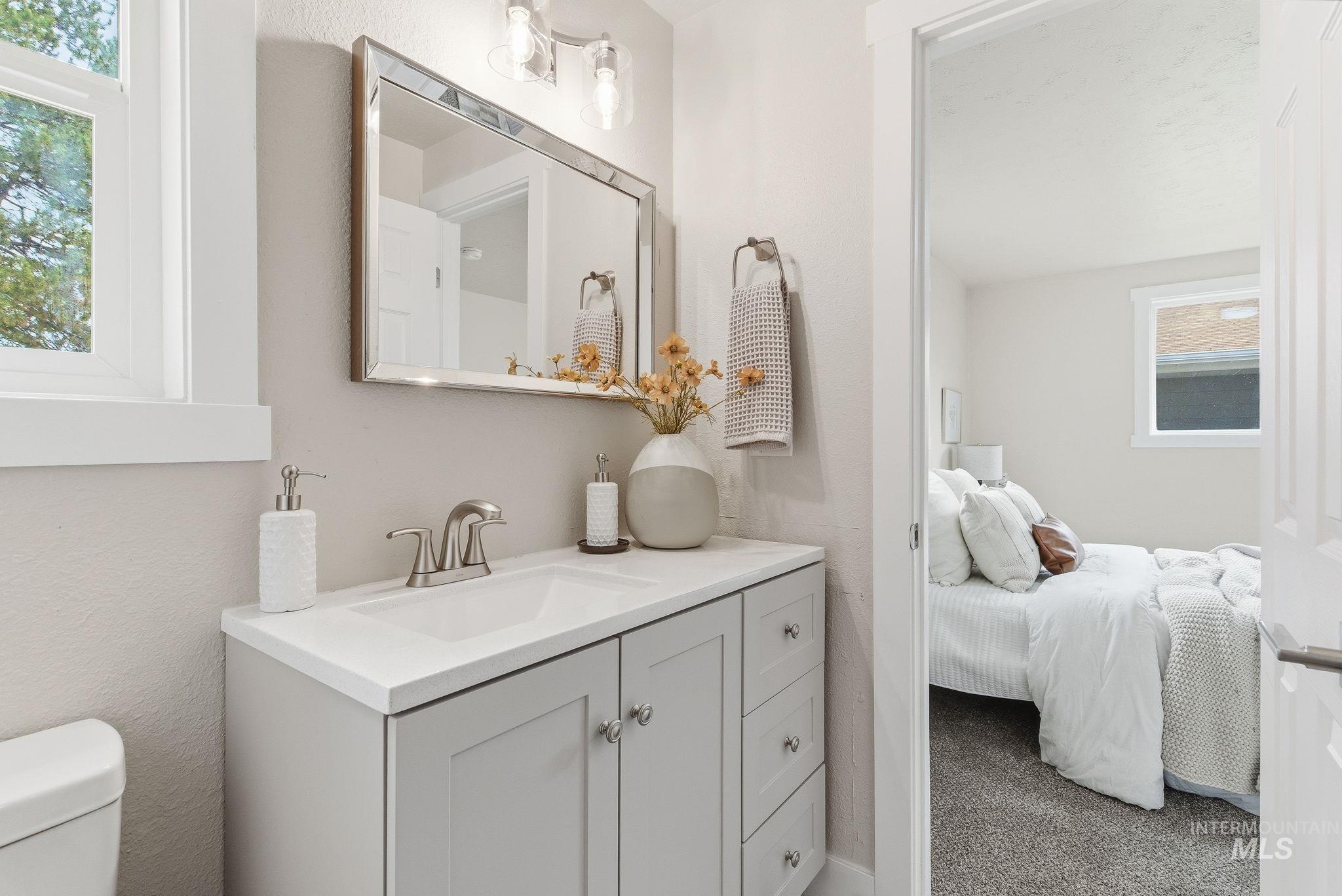 Bathroom featuring vanity, carpet flooring, ensuite bathroom, and a textured wall