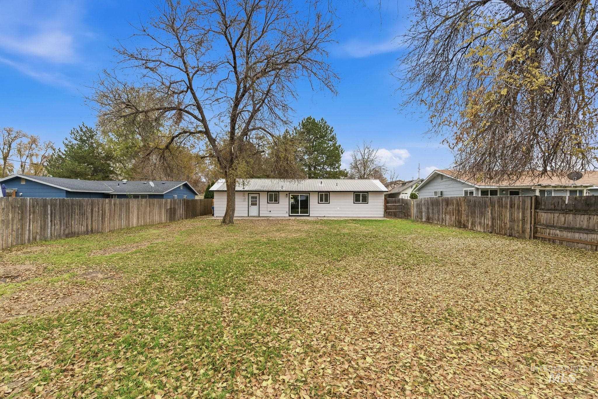 Rear view of house with a fenced backyard