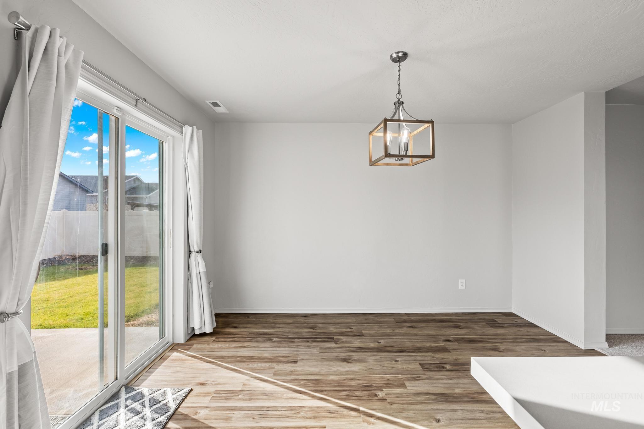 Unfurnished dining area featuring light wood-style flooring and a chandelier