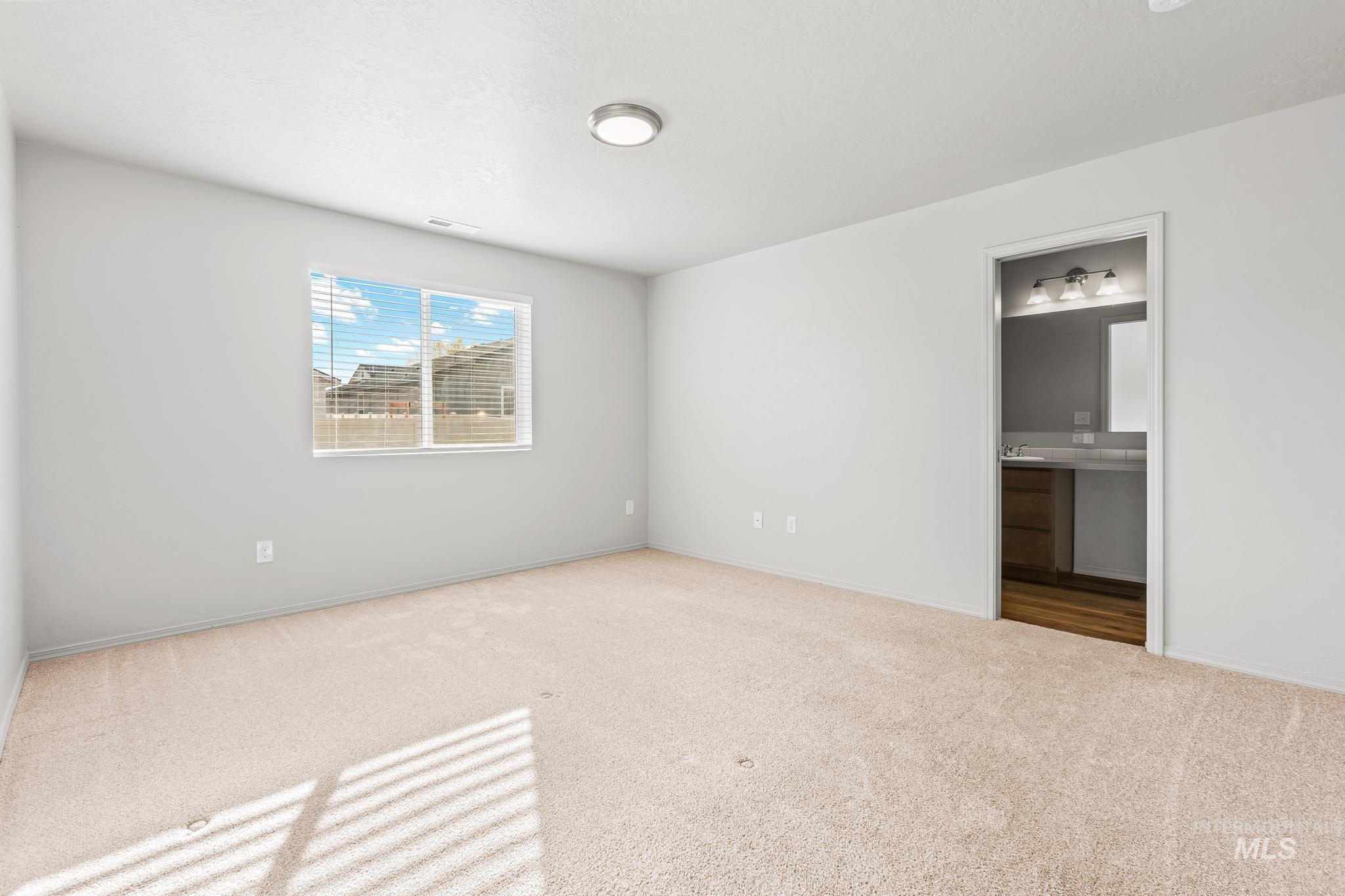 Unfurnished bedroom with carpet and ensuite bathroom