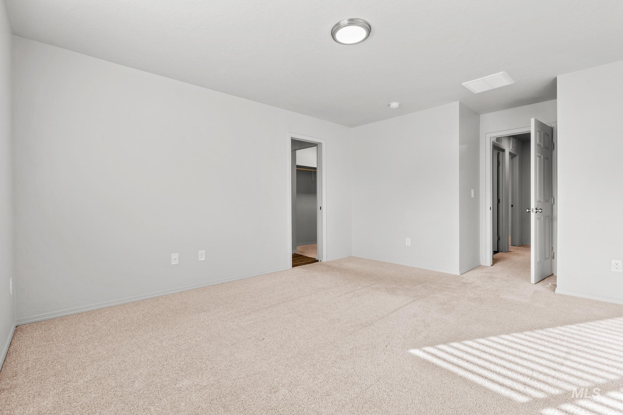 Spare room featuring light colored carpet and baseboards
