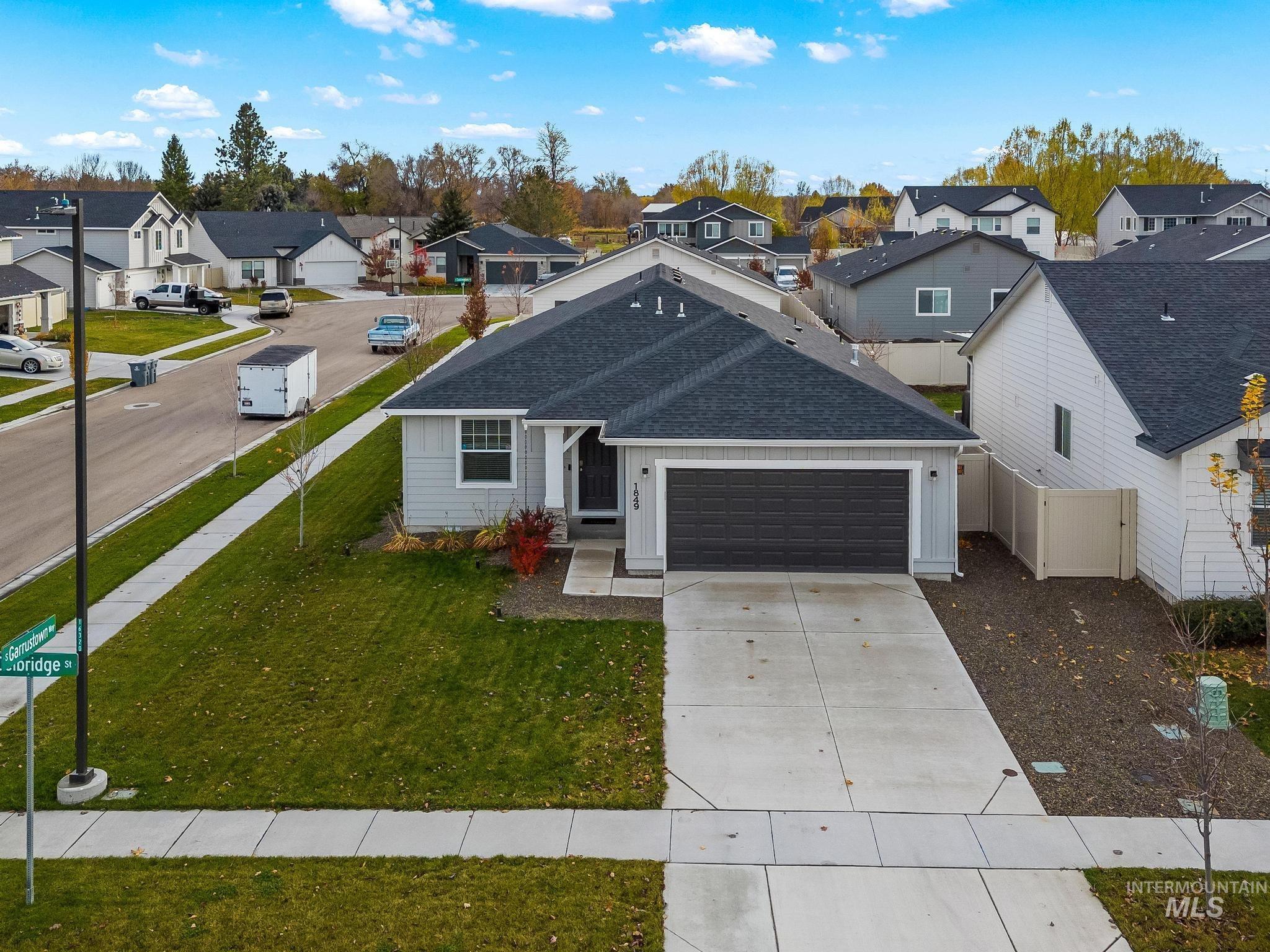 View of front of home featuring roof with shingles, board and batten siding, a residential view, concrete driveway, and a garage