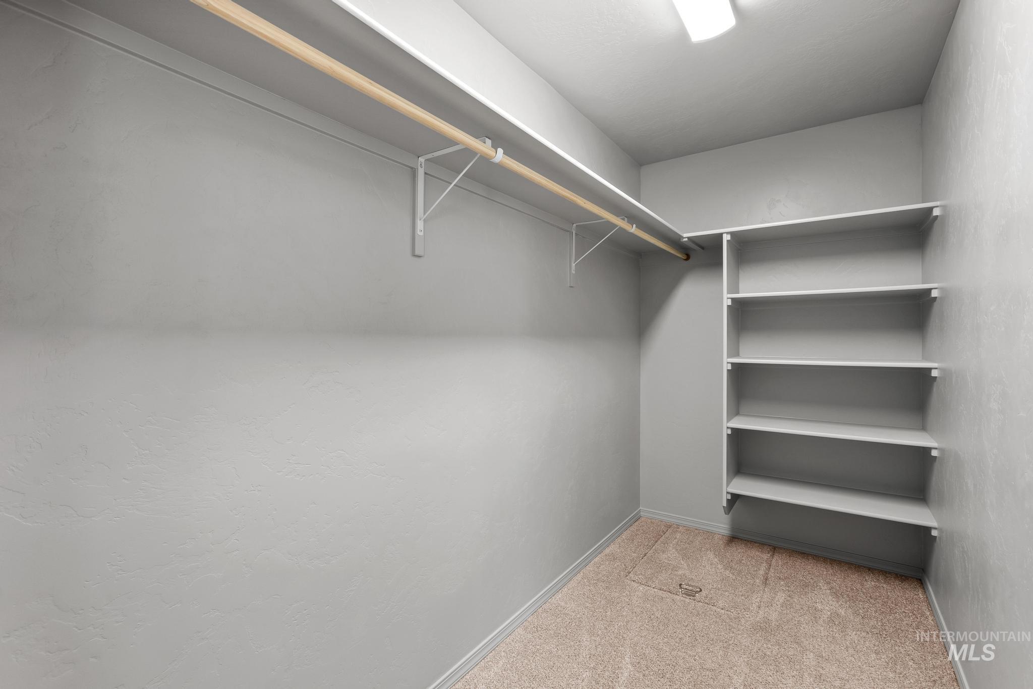 Walk in closet featuring light colored carpet