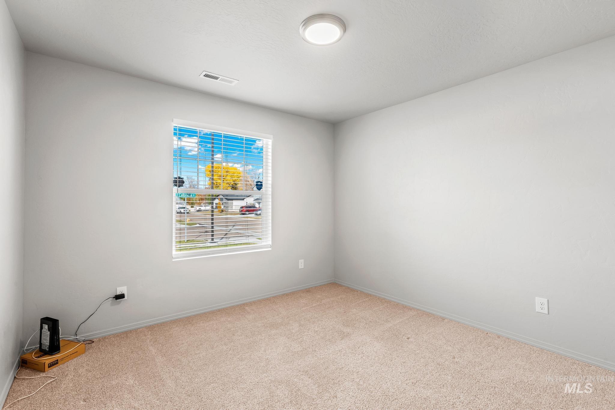 Unfurnished room featuring light colored carpet and baseboards