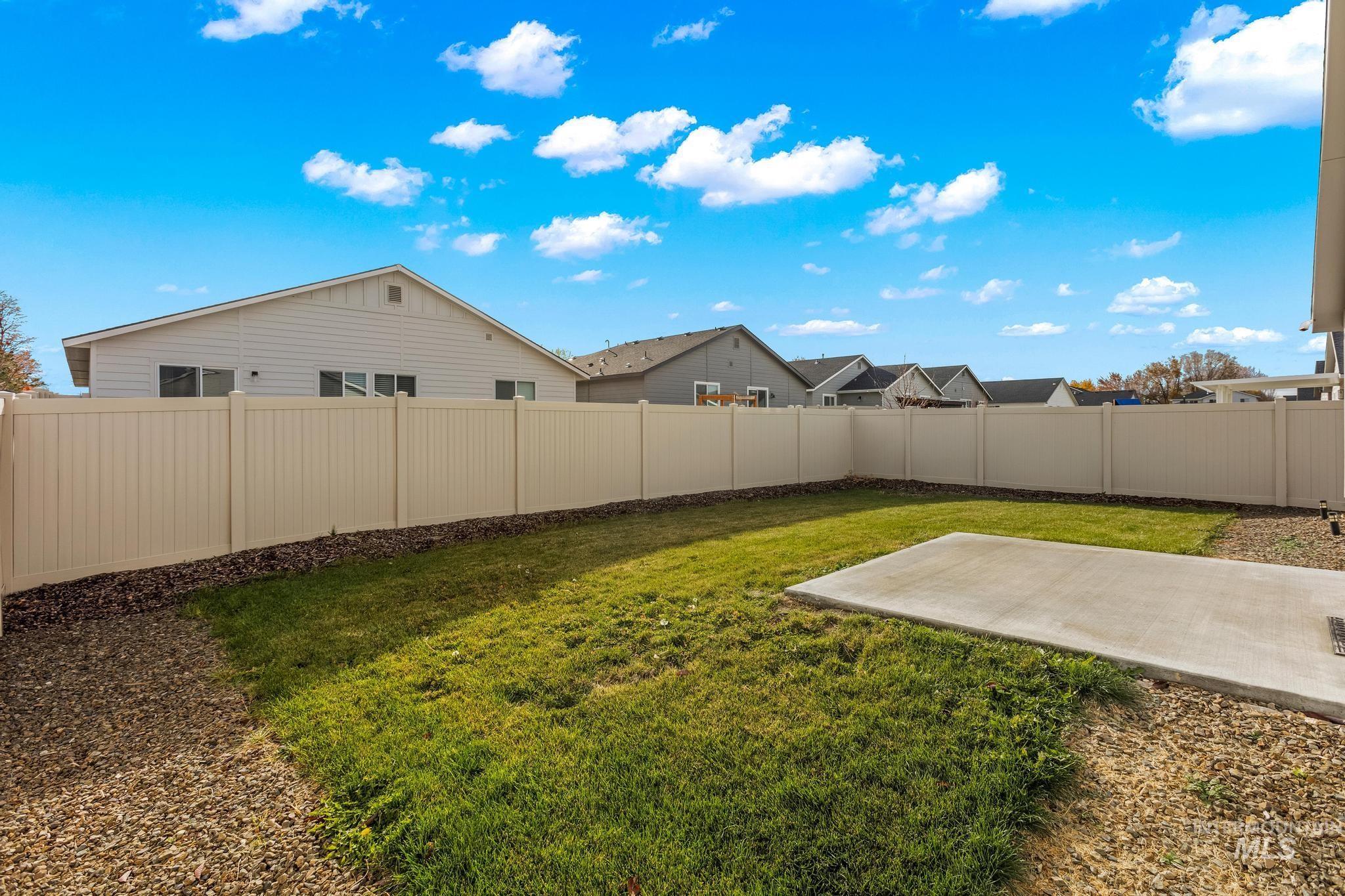 Fenced backyard featuring a patio and a residential view