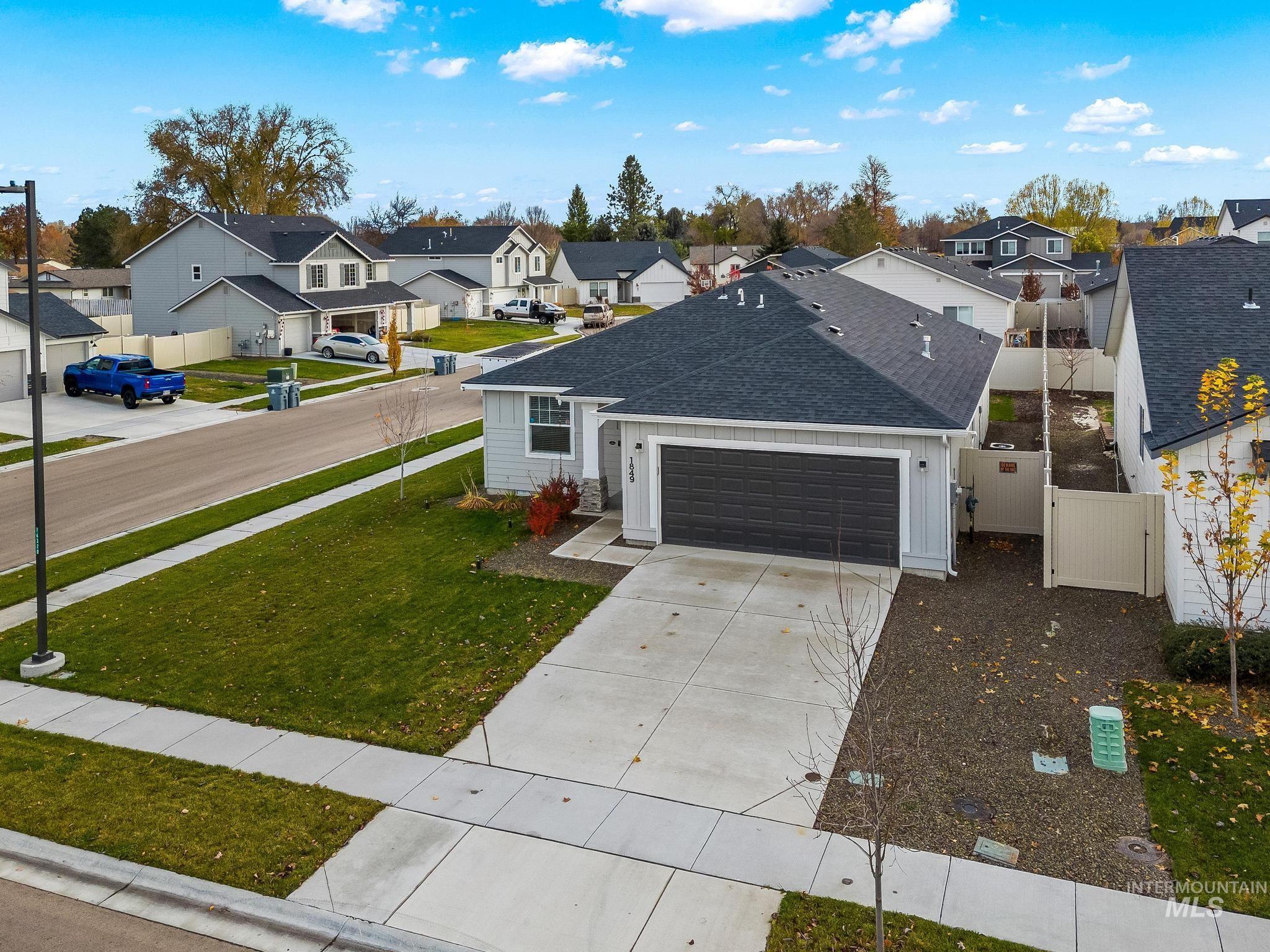 Traditional-style home featuring roof with shingles, board and batten siding, driveway, a residential view, and a garage