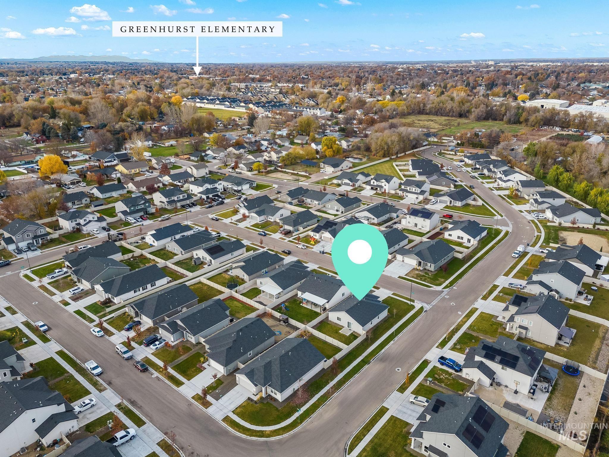 Aerial view of property and surrounding area featuring nearby suburban area