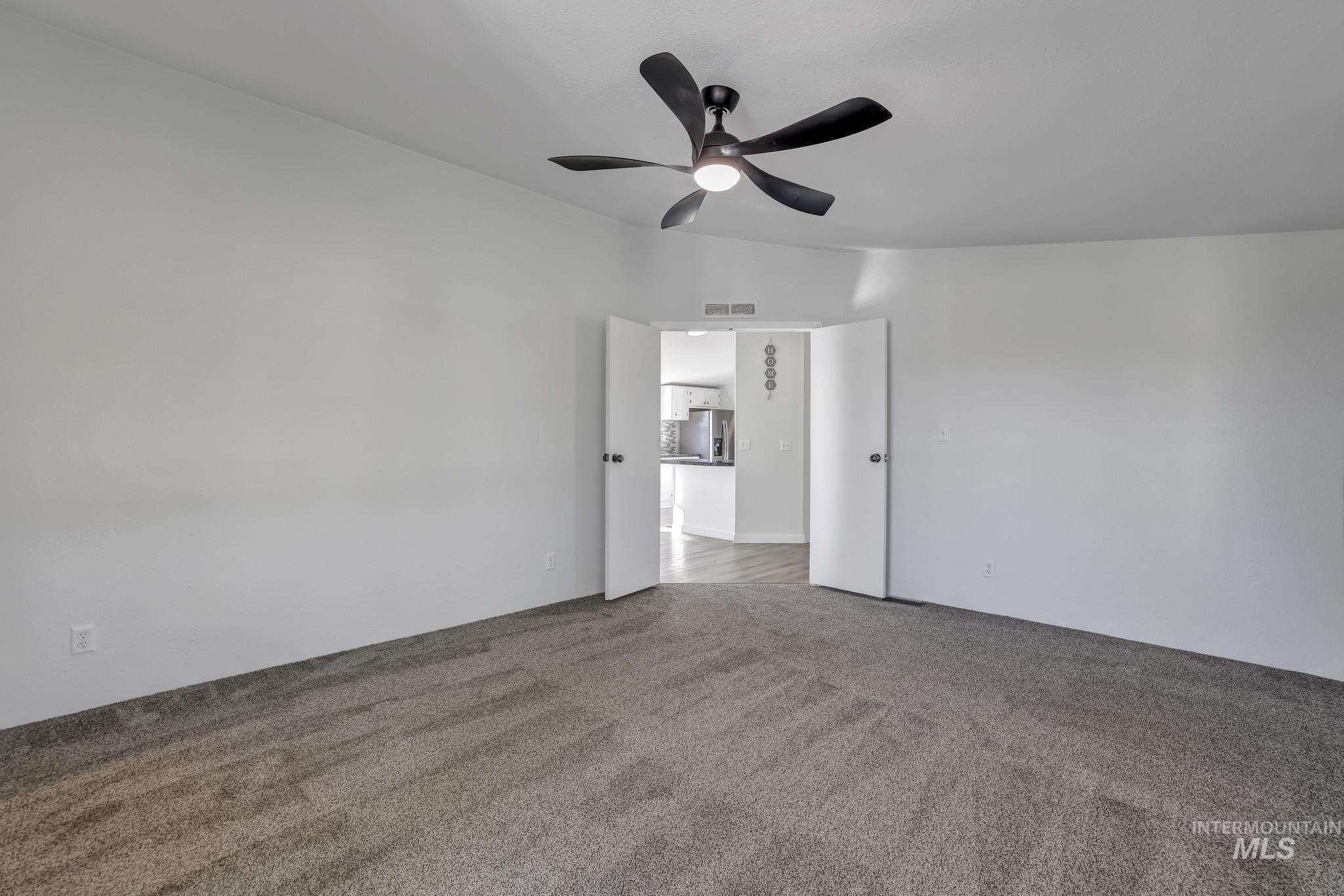 Primary bedroom with carpet and ceiling fan