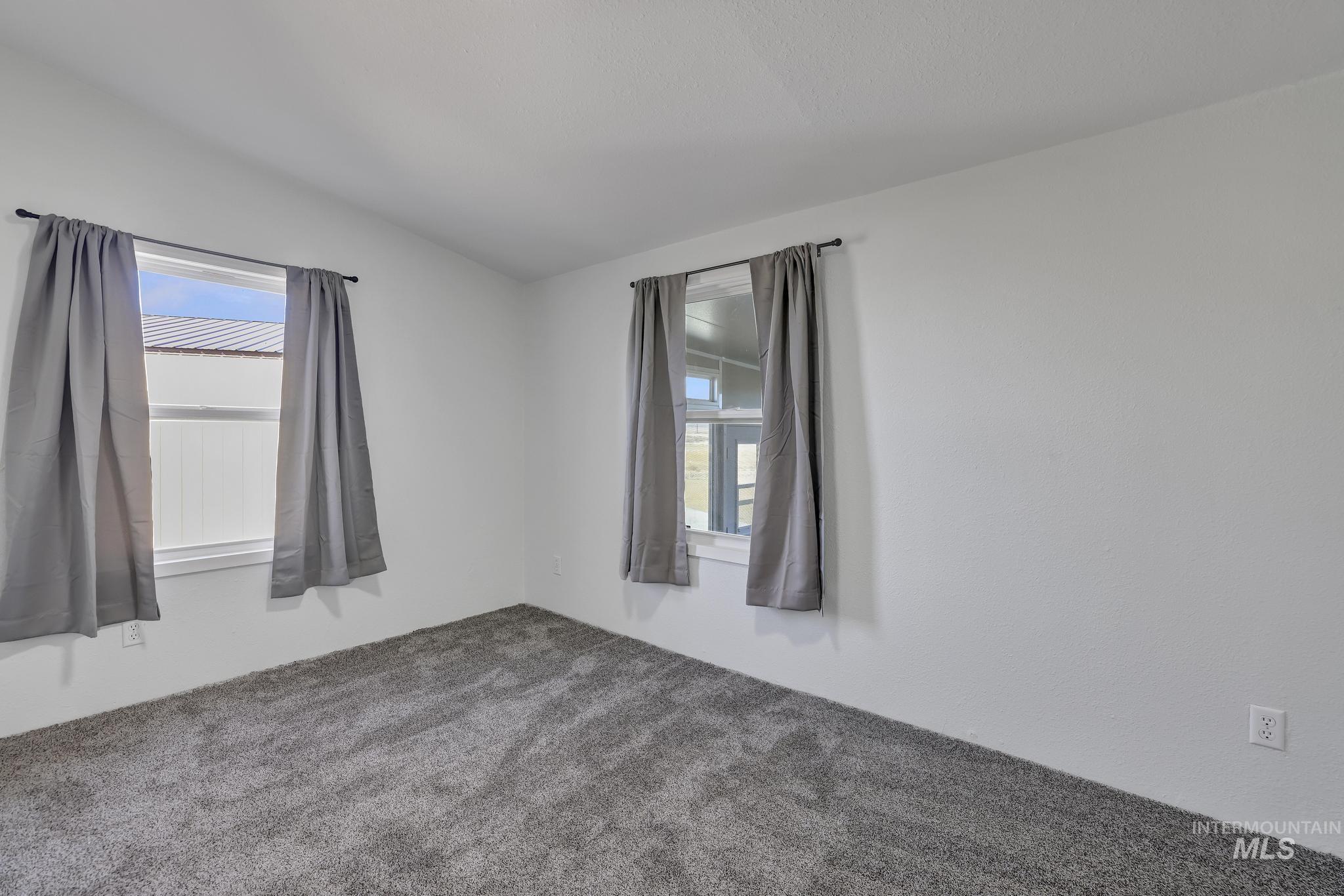 Unfurnished room with carpet and lofted ceiling