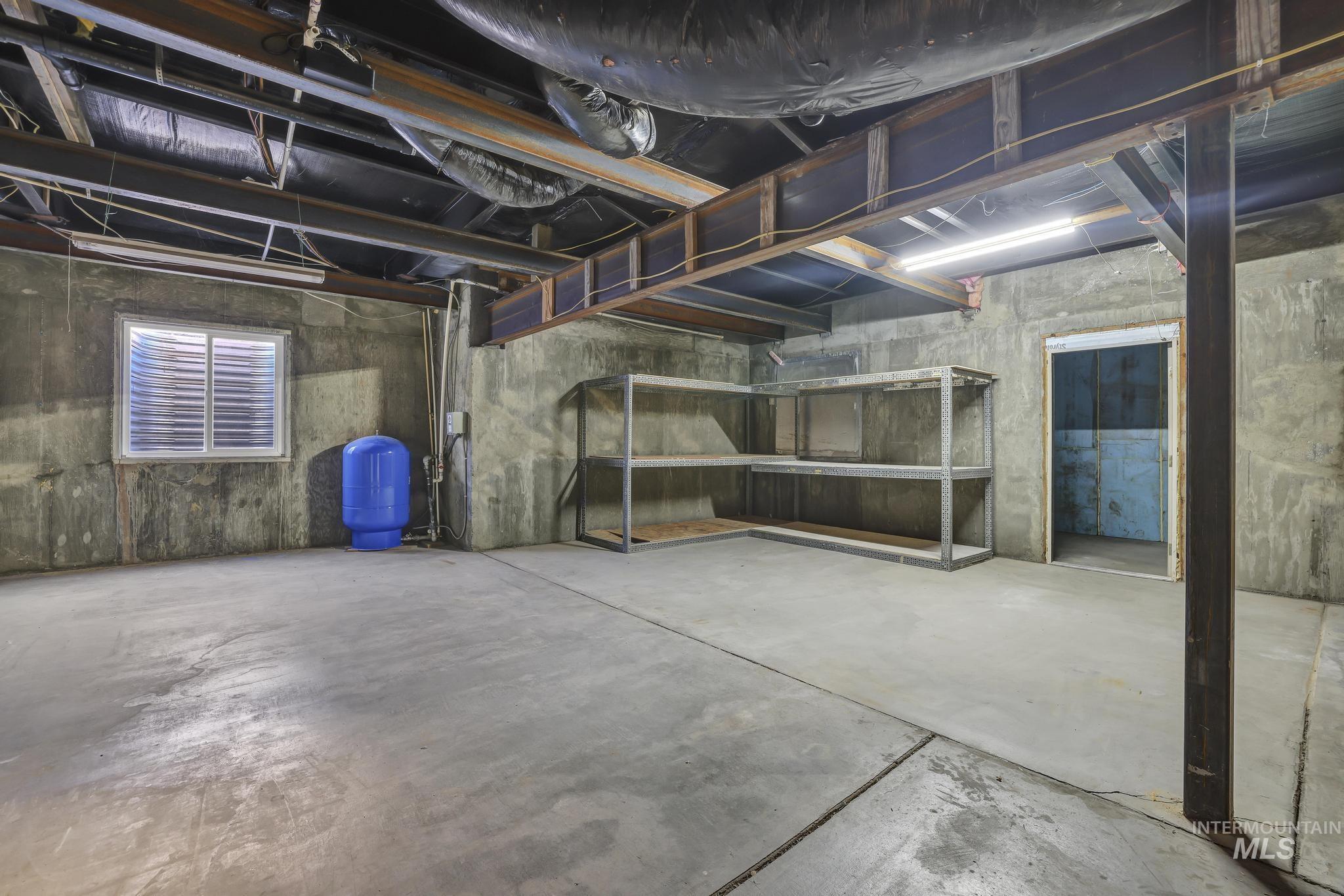 Unfinished basement featuring a water pressure tank