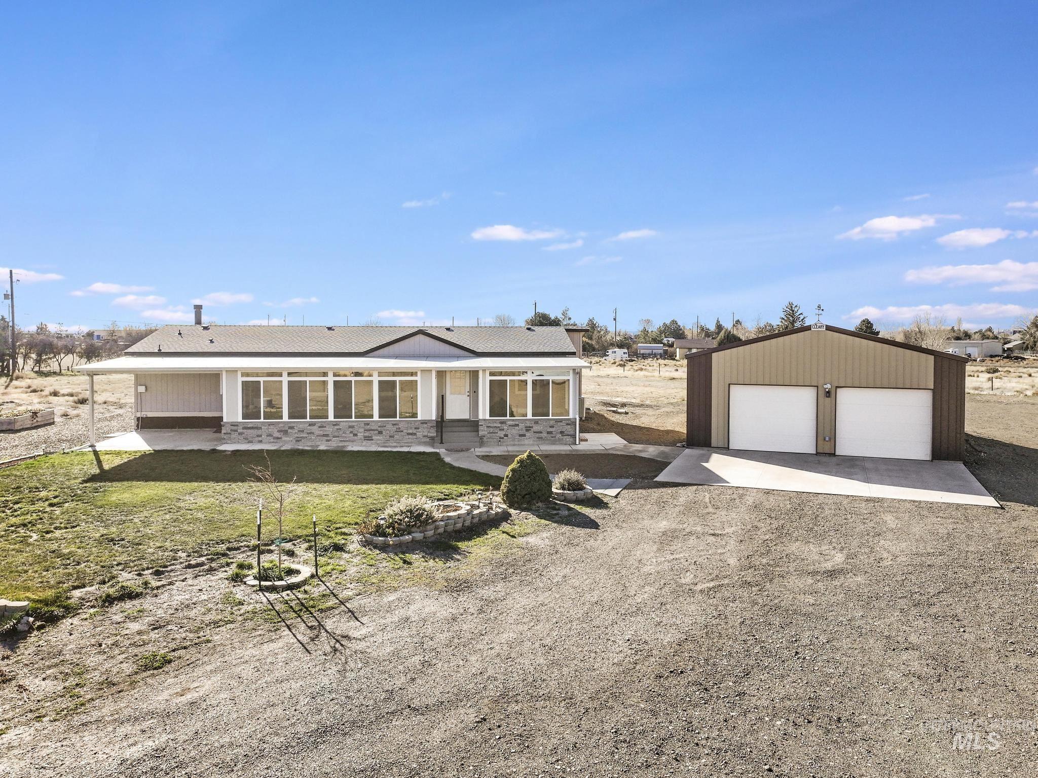 View of front of property featuring a patio, an outbuilding, and a garage