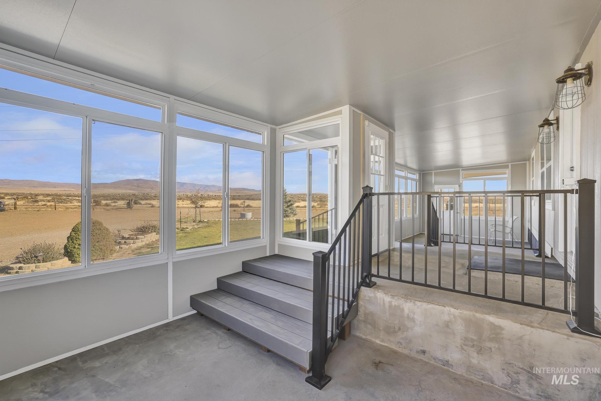 Sunroom with a mountain view and unfinished concrete floors.