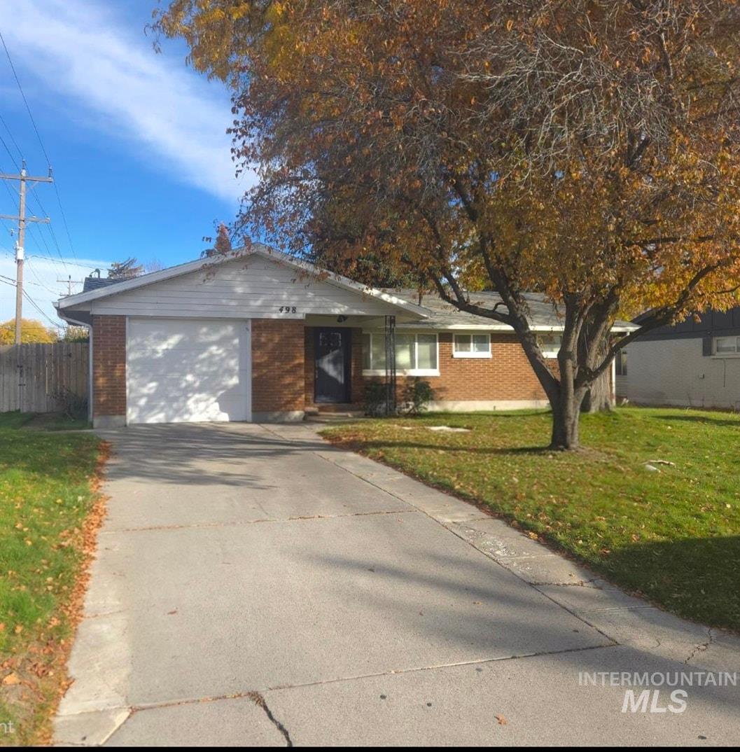 Single story home featuring concrete driveway and an attached garage