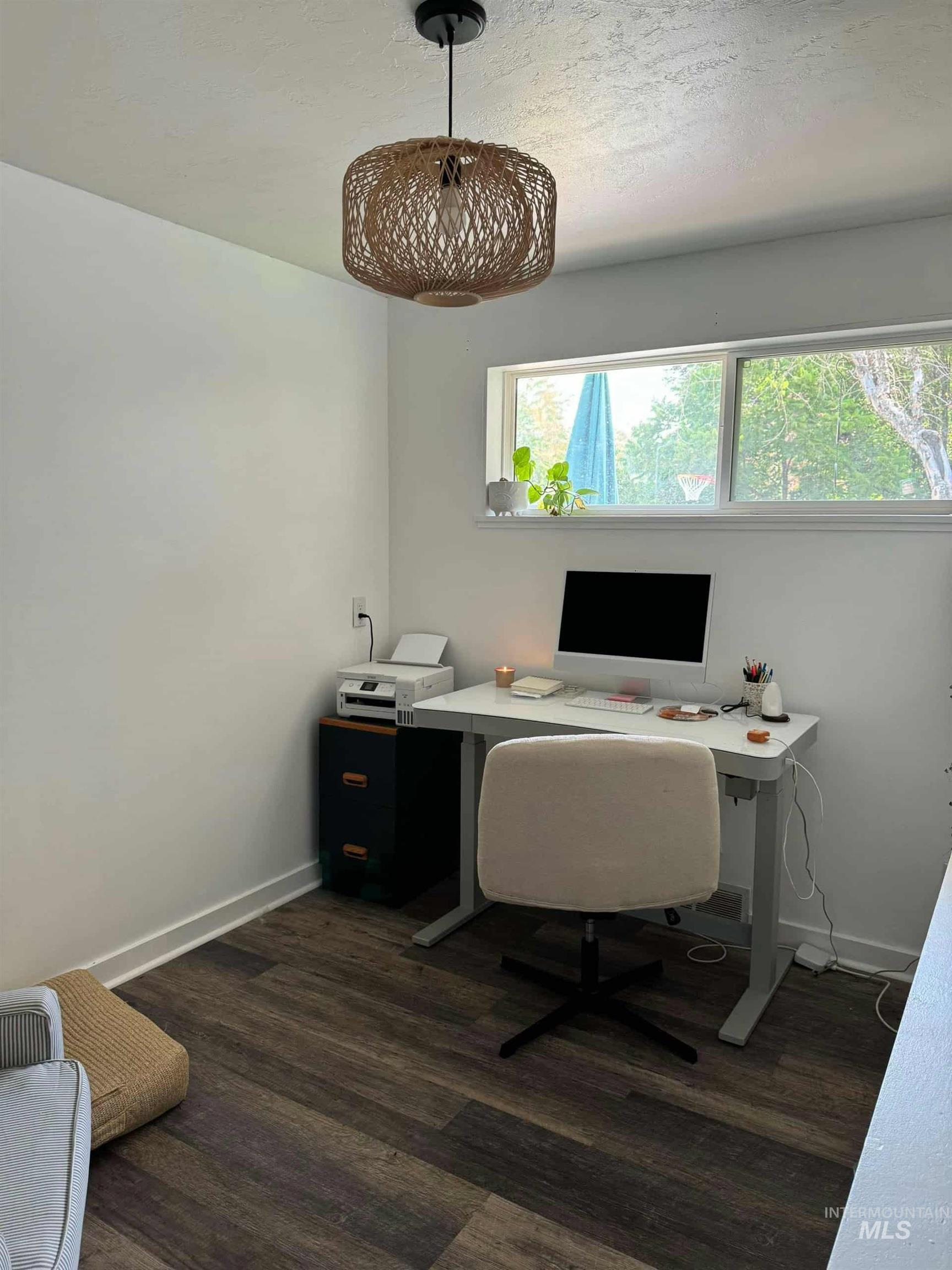 Office area with dark wood-type flooring and a textured ceiling