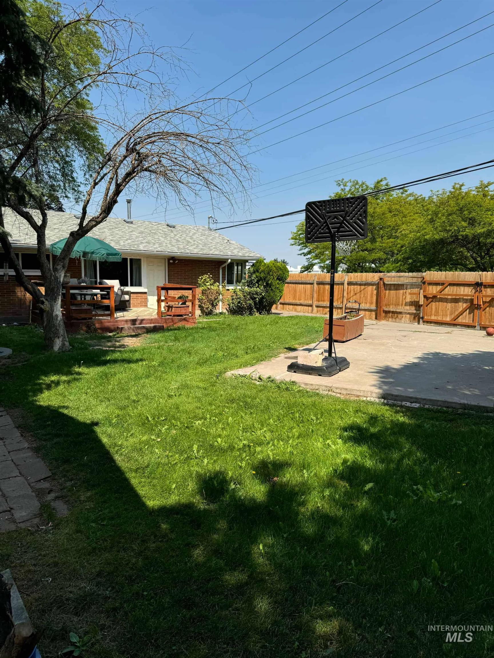 Fenced backyard featuring a deck and a patio