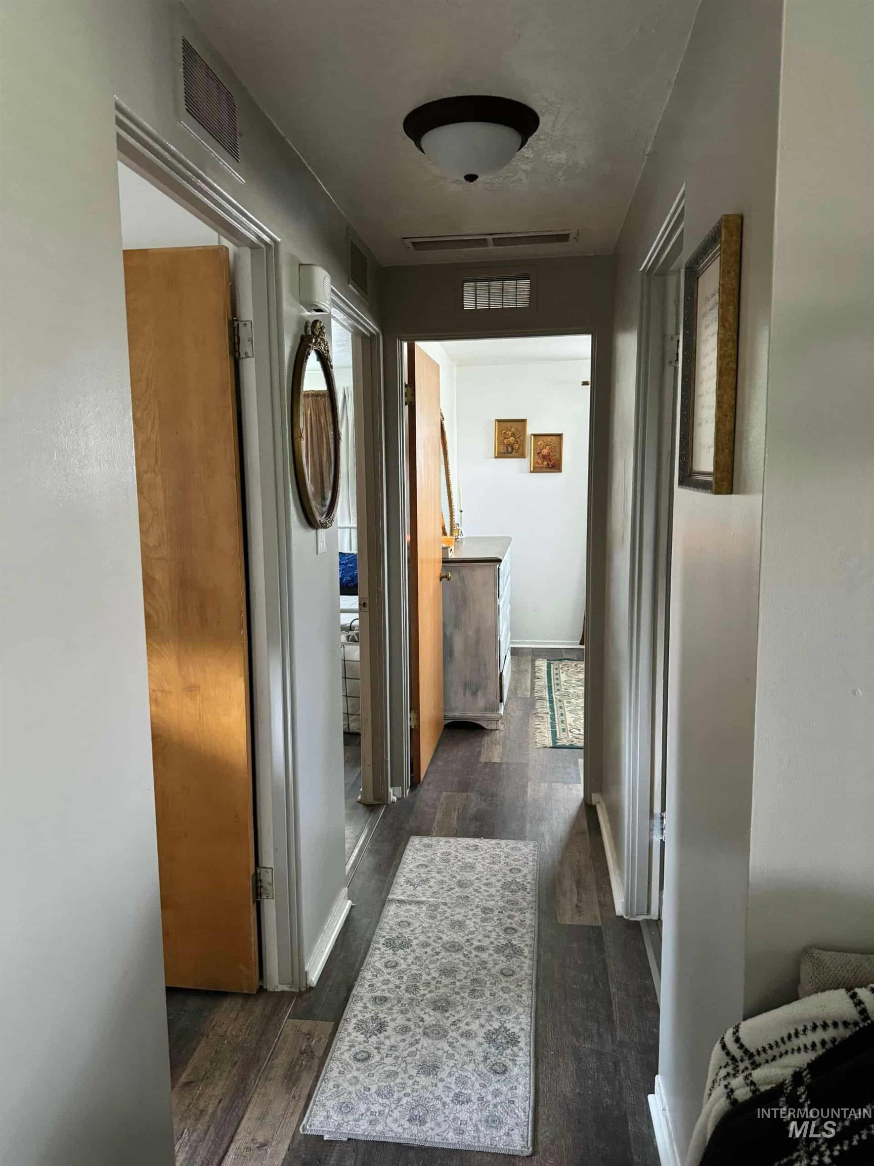 Hall featuring dark wood finished floors and baseboards