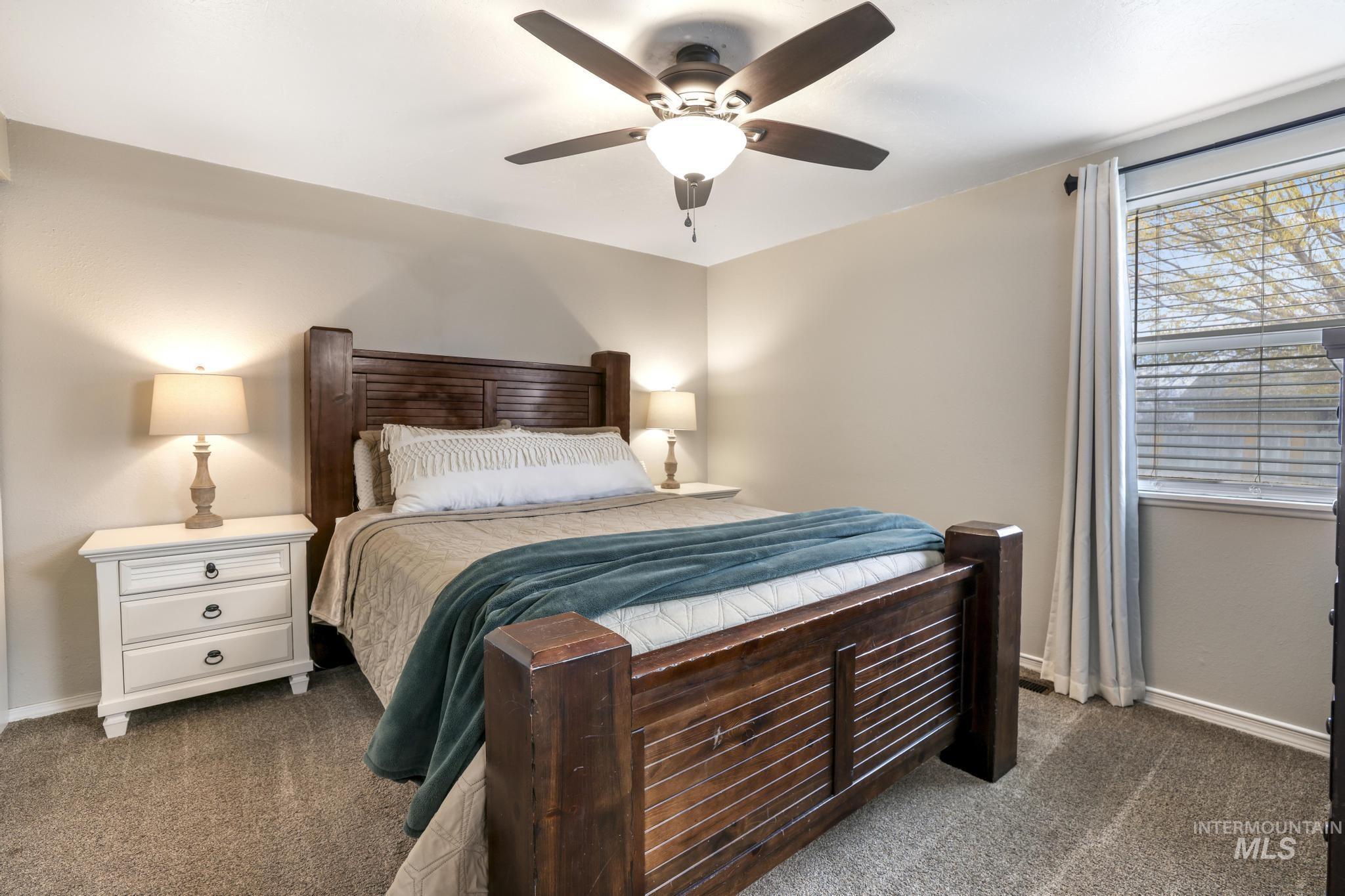 Bedroom featuring dark colored carpet and ceiling fan