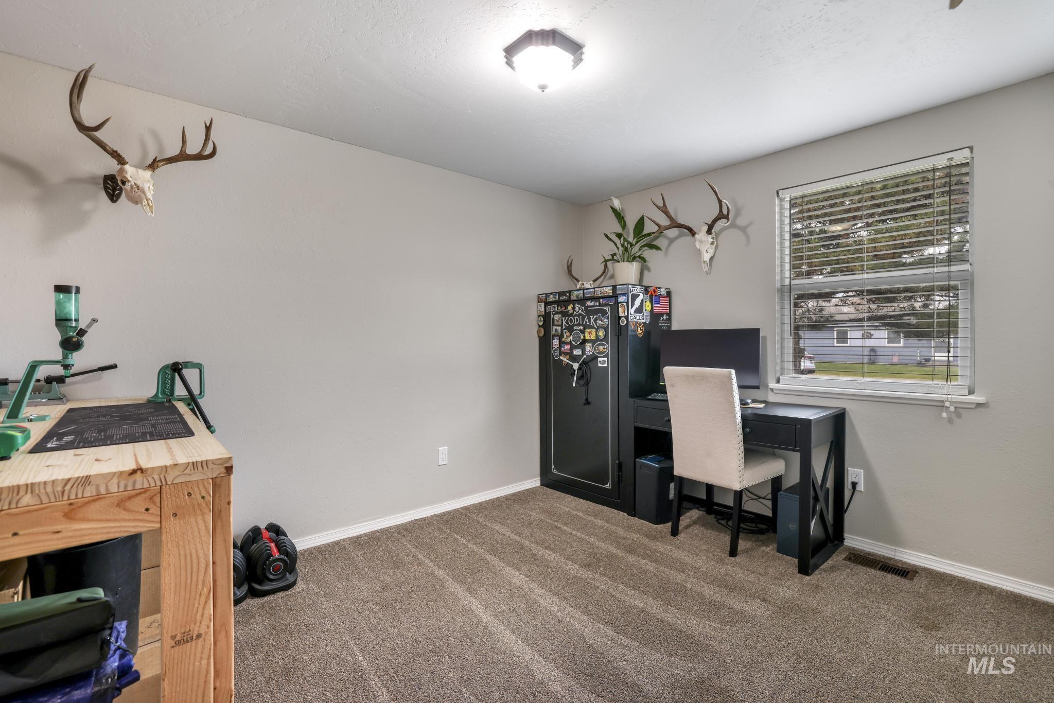 Carpeted home office featuring baseboards