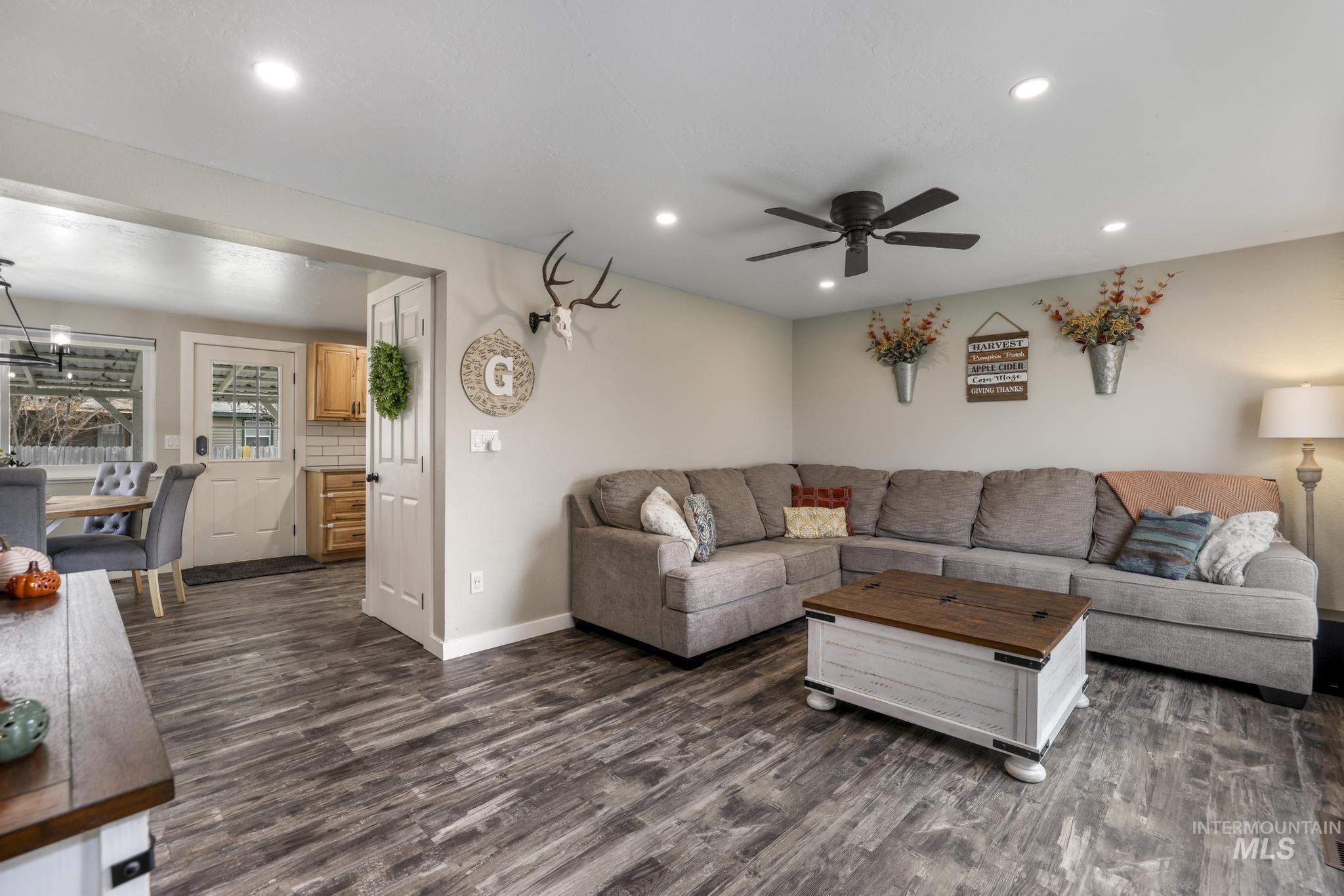 Living area with dark wood-style flooring, recessed lighting, and a ceiling fan