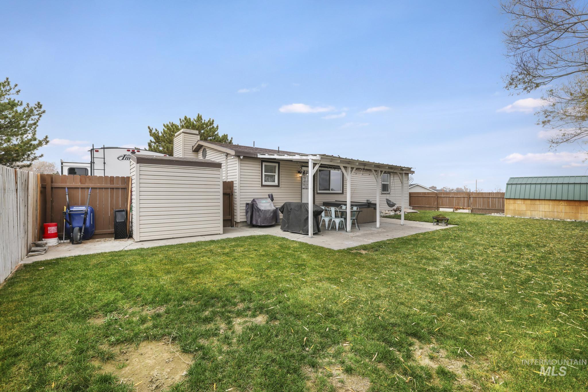 Rear view of property featuring a shed, a fenced backyard, and a patio area