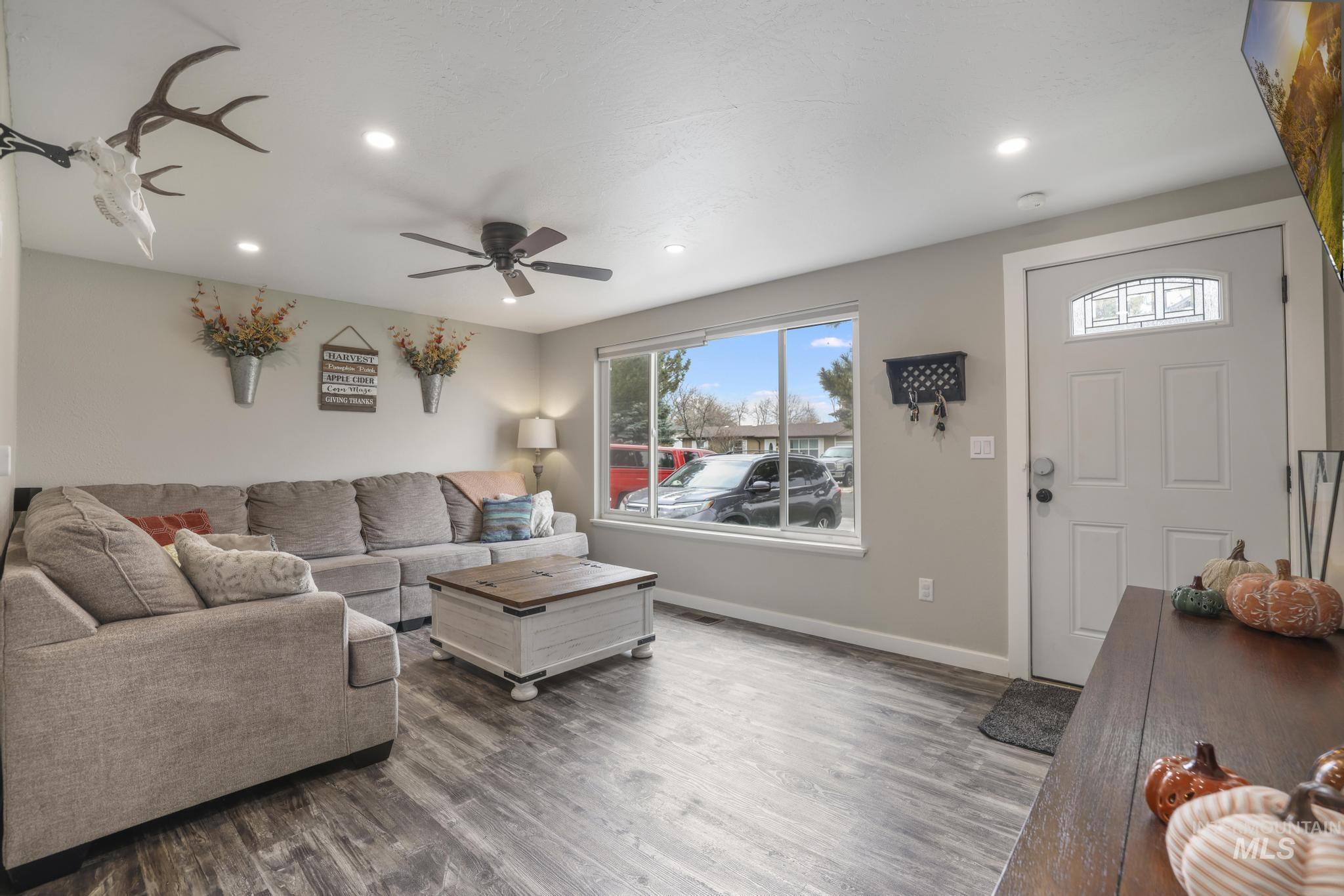 Living area with wood finished floors, a ceiling fan, and recessed lighting