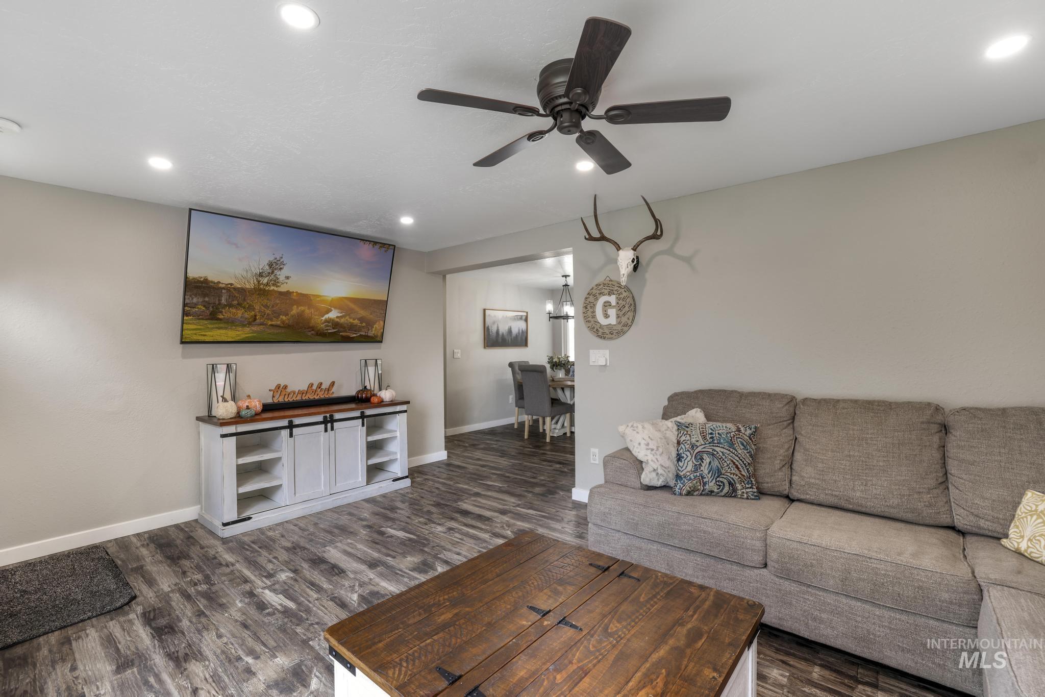 Living area featuring dark wood finished floors, recessed lighting, and ceiling fan