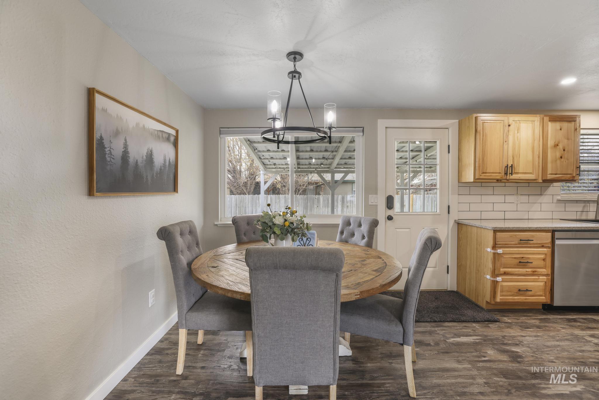 Dining space with dark wood-type flooring and a chandelier