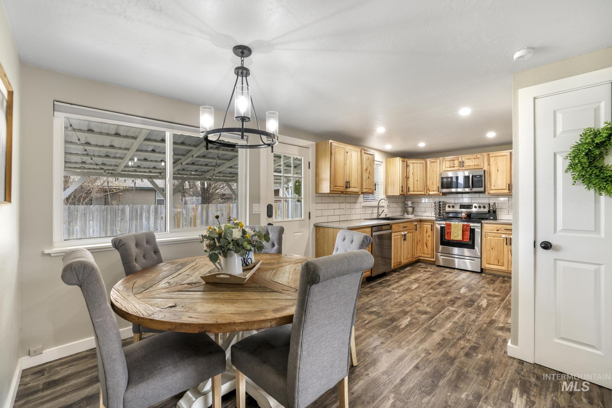 Dining room featuring a chandelier, dark wood-style floors, and recessed lighting