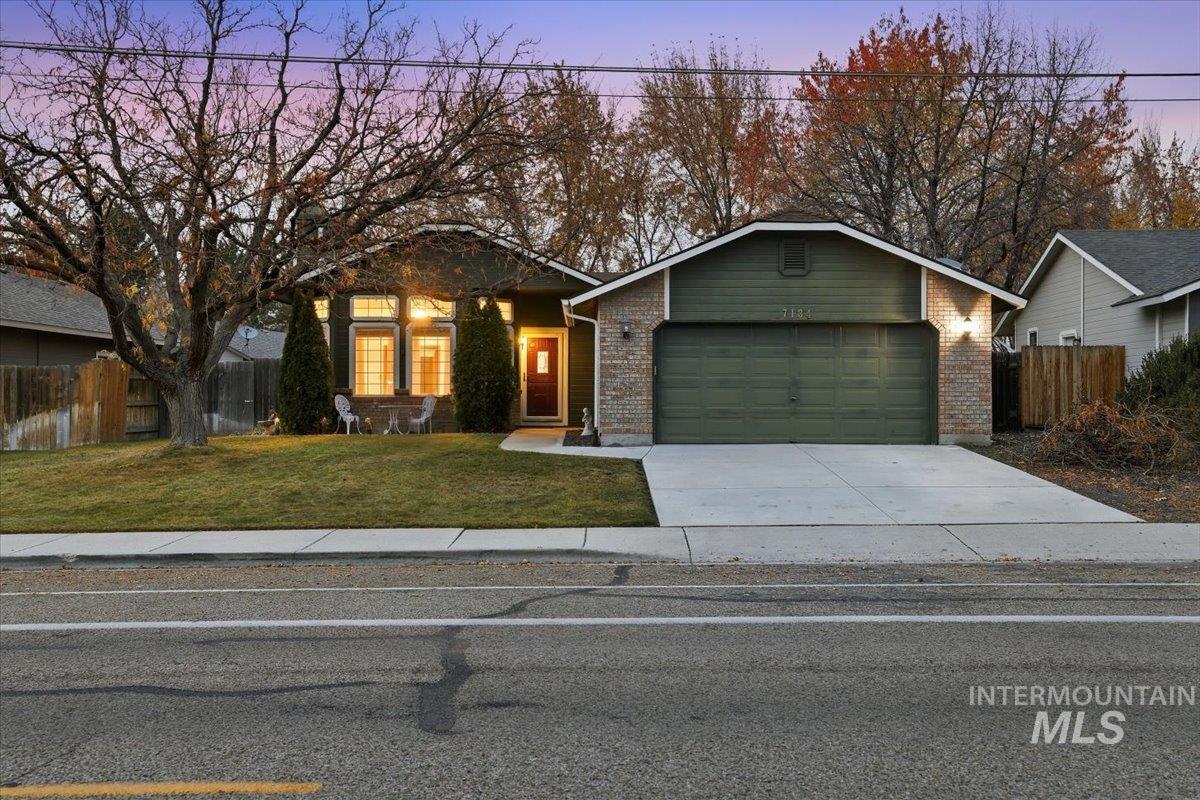 View of front of home featuring concrete driveway, brick siding, and an attached garage