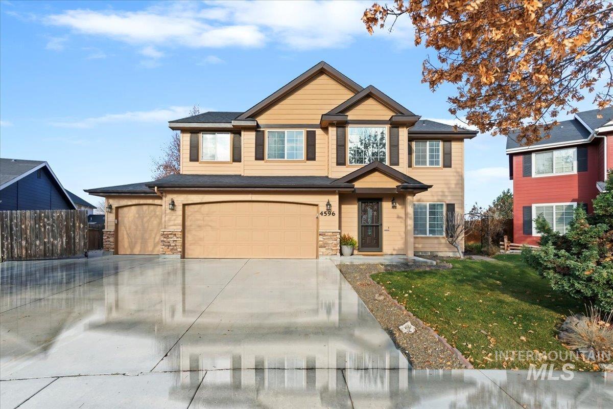 View of front of property with driveway, a garage, and stone siding