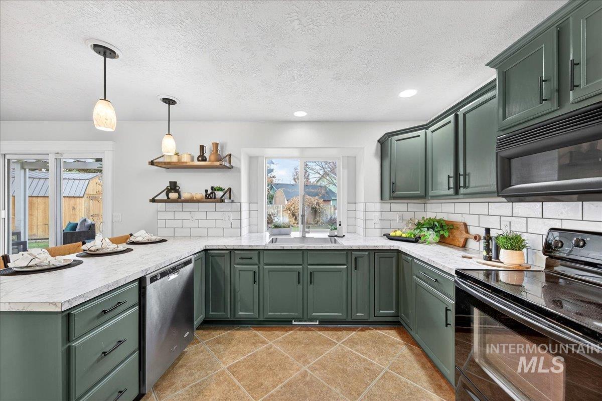 Kitchen with green cabinets, black appliances, backsplash, a textured ceiling, and recessed lighting