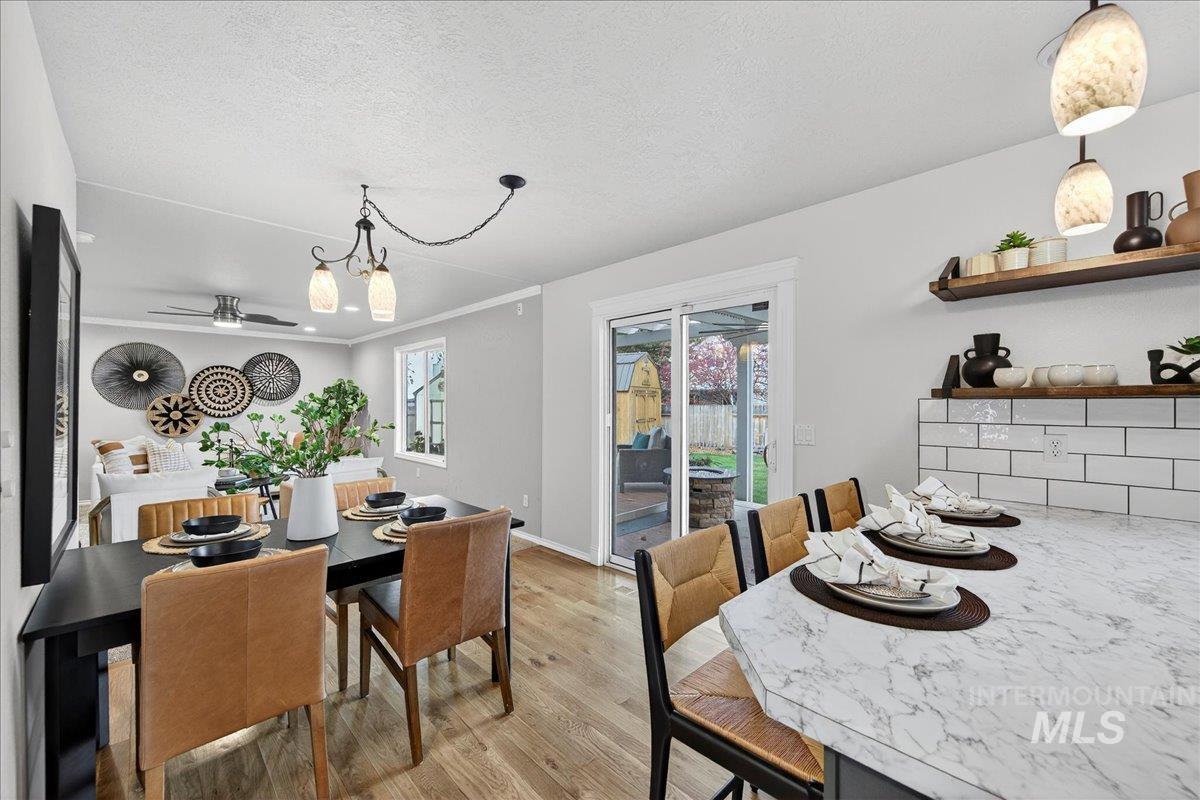 Dining space featuring light wood finished floors, a textured ceiling, and a chandelier
