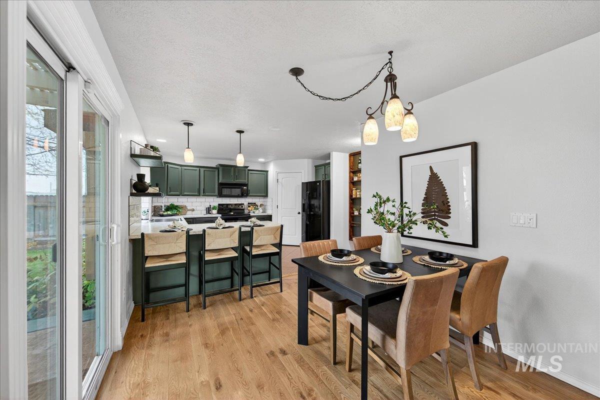 Dining space with light wood-type flooring and a textured ceiling