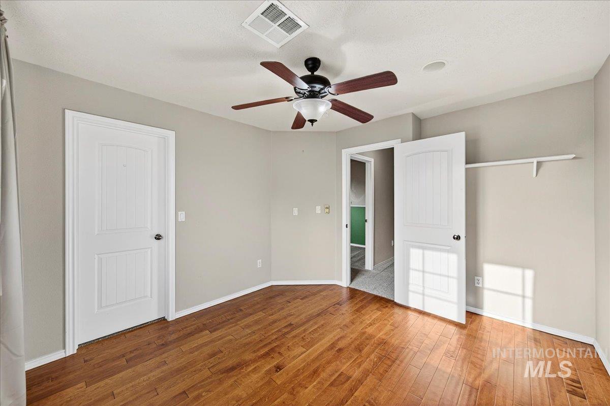 Unfurnished bedroom featuring hardwood / wood-style flooring and ceiling fan