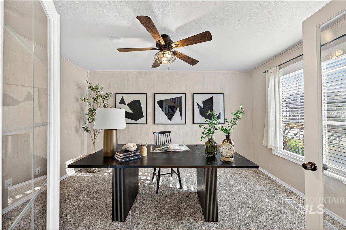 Carpeted office space featuring a ceiling fan, french doors, and crown molding