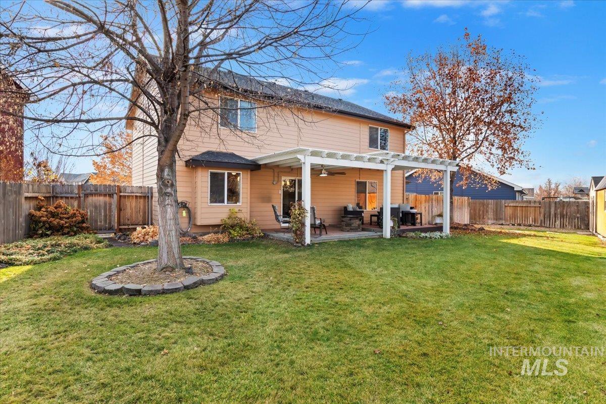 Back of property with a fenced backyard, ceiling fan, a patio, and a pergola