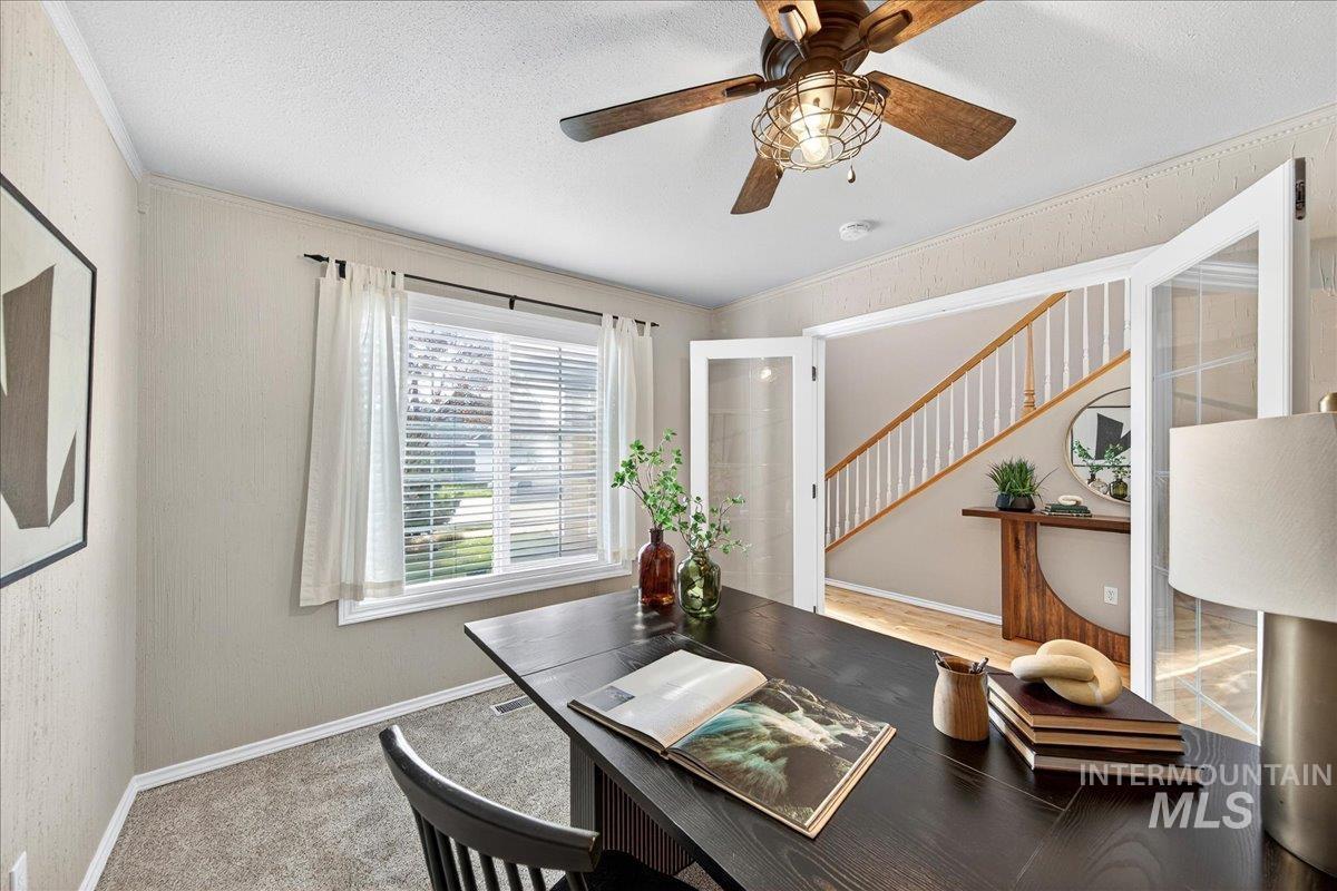 Carpeted home office featuring crown molding, a textured ceiling, and ceiling fan