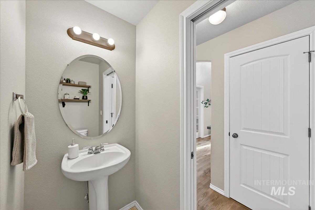Half bathroom with wood finished floors and baseboards